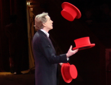A man juggling 3 red hats. Photo by Usien on wikimedia commons.